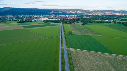 Aerial Capture of Countryside Landscape with Long Empty Road and City in Background