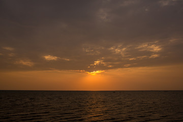 Obraz premium Bright sunset with large yellow sun under the sea surface. sunrise in the sea. Beautiful sunset above the sea. Tropical sunset on the beach.