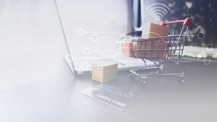 Boxes in a trolley on a laptop keyboard. Ideas about online shopping, Many paper box money and cradit card in shopping. Online shopping concept