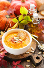 Bowl of pumpkin soup on rustic wooden background