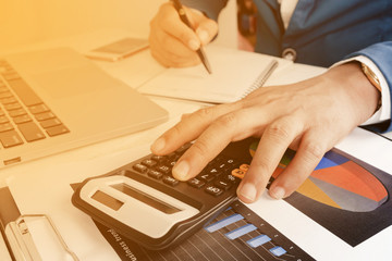 Business accounting plan concept, business man hand working with laptop computer on wooden desk...