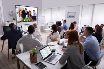 Businesspeople Attending Videoconference Meeting In Office