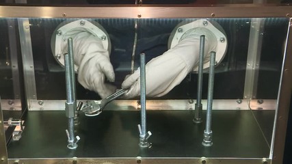 Simulator for training astronauts. With the hands of an astronaut in a spacesuit at the docking parts.