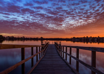 Fototapeta na wymiar Looking down the Jetty, with a colorful Sky at Sunset in Perth Australia