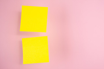 Two yellow paper stickers hanging in the air (levitate) on a pink background