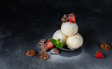  ice cream balls  with strawberries and walnuts on a dark background, selective focus and copy space, Italian gelato, recipe  ice cream