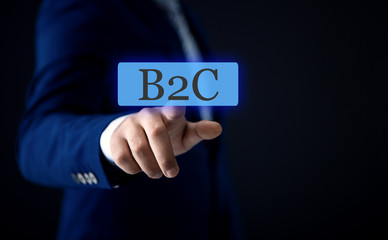 businessman on the touch screen with a finger clicks on the text B2C