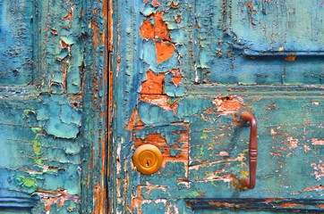 texture of a very old wooden door, in which a new lock is cut , with cracked and crumbled paint