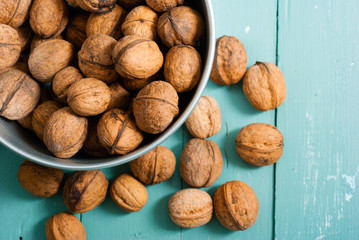 walnuts at tin bowl, old blue table background