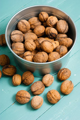 walnuts at tin bowl, old blue table background