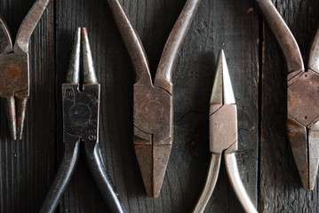 old pliers on black wood background directly above