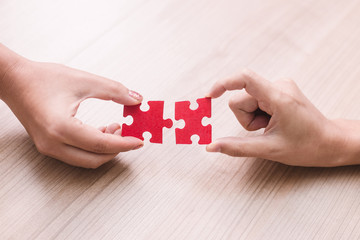 woman hand holding jigsaw puzzle pieces in office