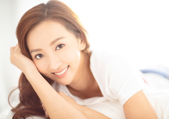Fototapeta premium closeup young asian smiling woman on bed
