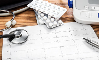 Doctor's workplace with cardiogram, pills, stethoscope and tonometr. Medical concept.