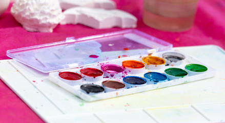 Multi-colored paints are on the table