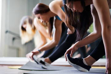 Fototapeta na wymiar Activity, sport, endurance, good mood, healthy lifestyle. Women group workout. Sporty ladies stretching during yoga class