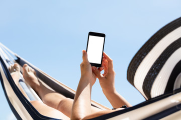 Woman Lying On Hammock Using Mobile Phone