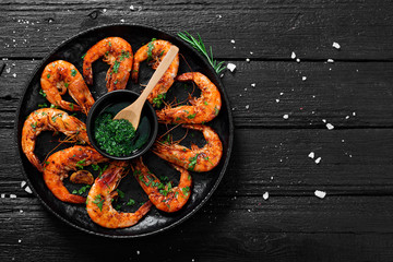 Tasty appetizing roasted shrimps prawns with spices and green sauce.