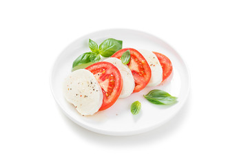 Mozzarella with tomatoes and basil leaves isolated on white background.