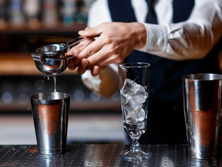 barman at work. A young bartender works with a shaker. Prepares delicious alcoholic cocktails