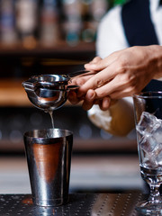 barman at work. A young bartender works with a shaker. Prepares delicious alcoholic cocktails