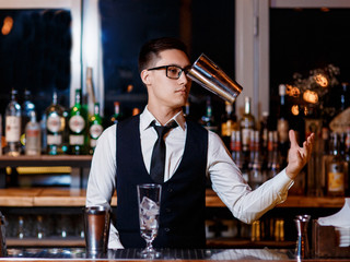 barman at work. A young bartender works with a shaker. Prepares delicious alcoholic cocktails