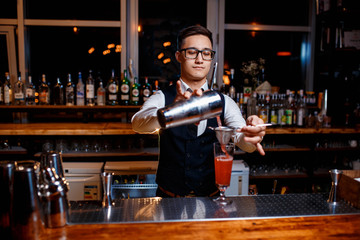 The bartender prepares a delicious orange cocktail with citrus. bartender at work