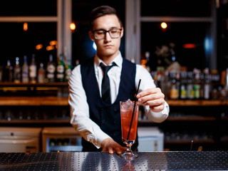The bartender prepares a delicious orange cocktail with citrus. bartender at work