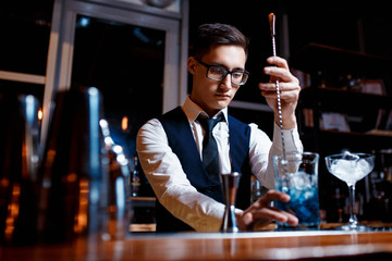 The bartender prepares a cool blue lagoon cocktail. Barman at work