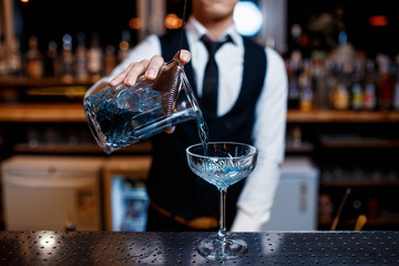 The bartender prepares a cool blue lagoon cocktail. Barman at work