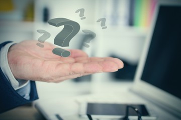 Businessman with question marks in his hand