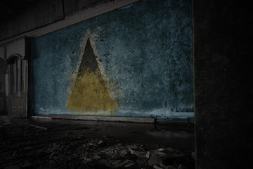 painted flag of saint lucia on the dirty old wall in an abandoned ruined house.