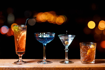 Cocktails on the background of the night city. Spirits on the background of multi colored round bokeh