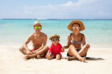 Portrait Of A Family Sitting On Sand At Beach