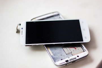 Cell phone is broken. White background with a mobile phone with a broken screen, closeup.
