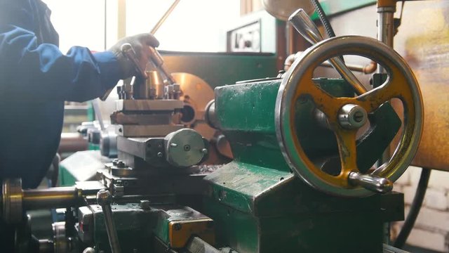 Industrial concept. Construction plant. A man working with a lathe - torque the detail and make machine work