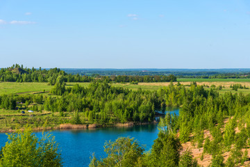 Fototapeta na wymiar Aerial view of picturesque hills and blue lakes in Konduki, Tula region, Russia. Turquoise quarry in Romantsevo.