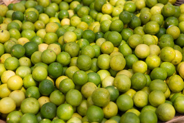 close-up of a basket filled with lemons and limes at a food market somewhere in the south of india