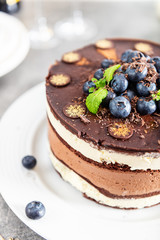 Belgian Chocolate Layered Gateau. Layers of moist choco sponge, vanilla cream and indulgent dark chocolate mousse glazed with rich dark chocolate sauce and hand decorated with fresh blueberries