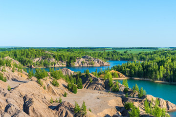 Aerial view of picturesque hills and blue lakes in Konduki, Tula region, Russia. Turquoise quarry in Romantsevo.
