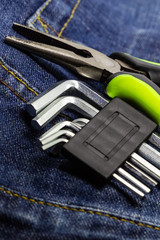 tools for repairing furniture on the background of jeans. keys for furniture and pliers