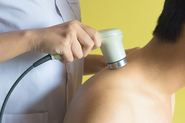 Physicaltherapist using ultrasound probe on patient shoulder for release pain.