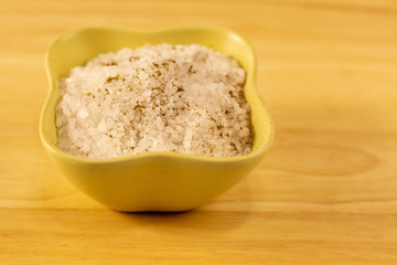 ceramic bowl full salt large white crystal many slice on a wooden background