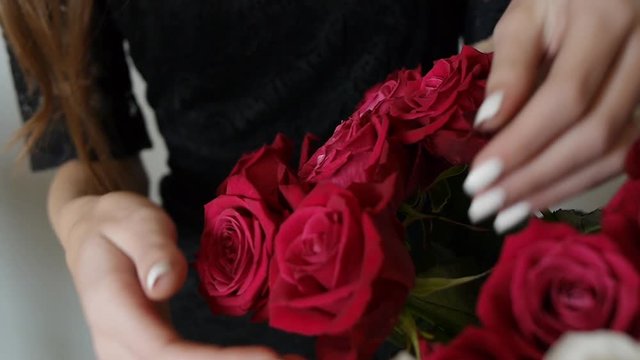 Woman Holds a Bouquet of Red Roses