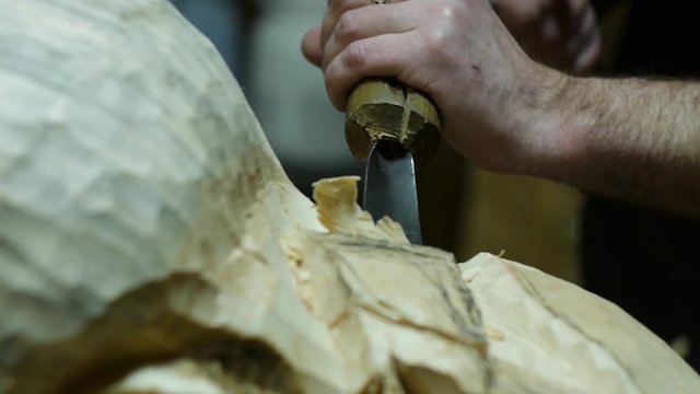 the sculptor carves a figure from a tree