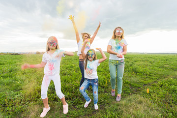 Obraz premium Holi festival, holidays and happiness concept - young teens and women in colors have fun outdoor