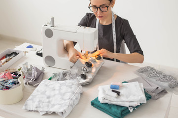 People, tailor and fashion concept - young fashion designer in her workplace