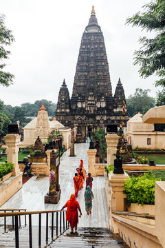 Indian people walking on bare foot to Mahabodhi Temple for pray and pilgrim while raining at Bodh Gaya, Bihar, India