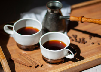Metal turk and two coffee cups on wooden tray background