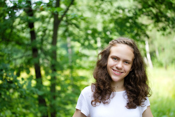 happy smiling young girl portrait in a green nature park